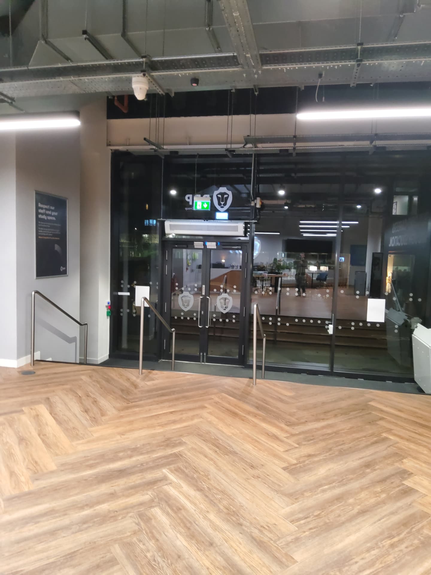 Wide view of the building entrance lobby with the new heater in place above the doors.