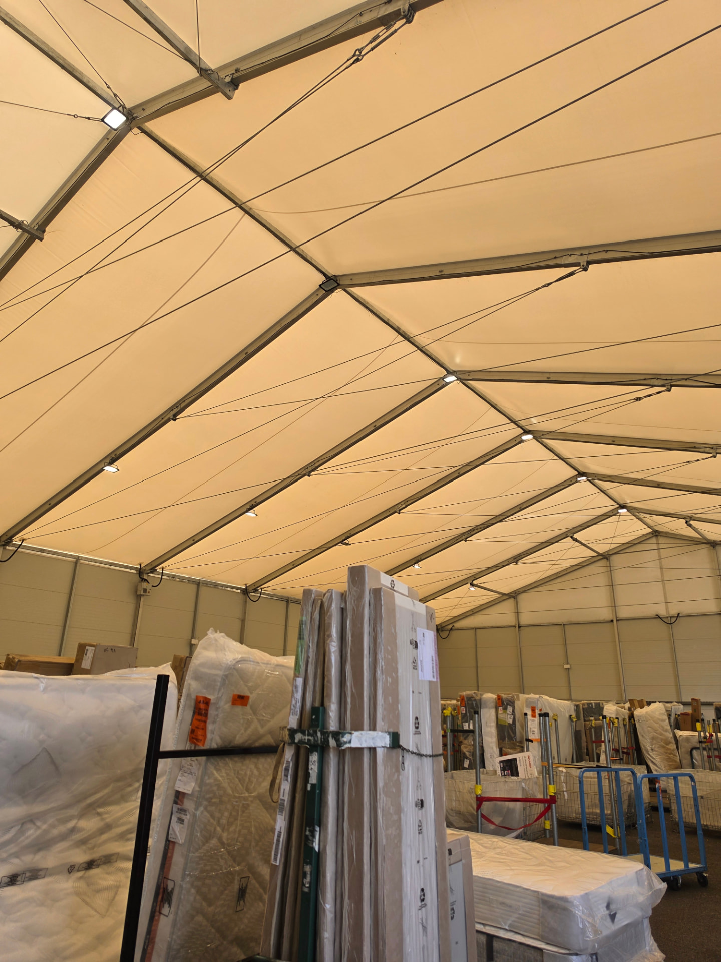 Wider view of the warehouse roof lighting above stored goods.