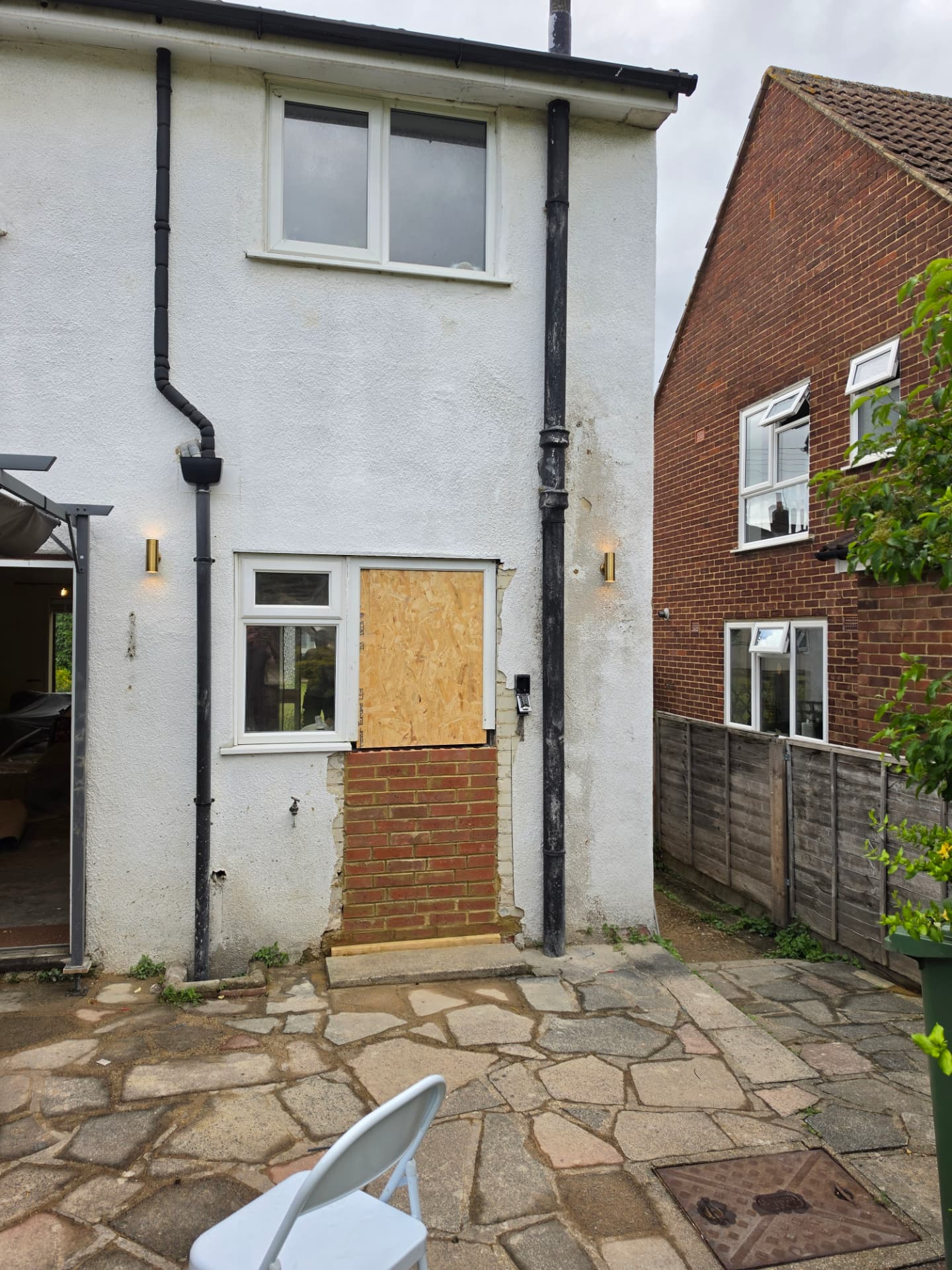 Two brass exterior wall lights fitted to the rear elevation of the house.