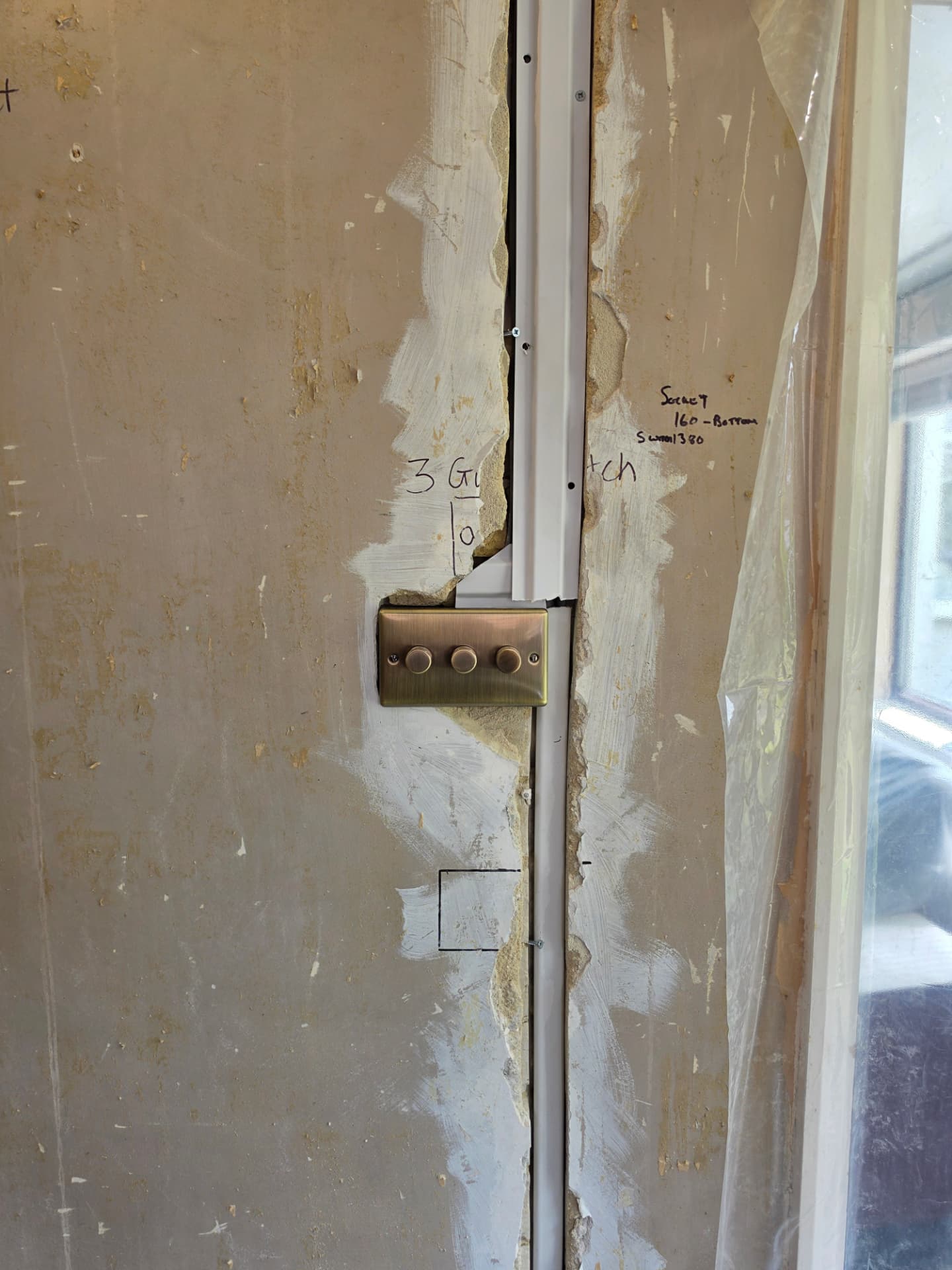 A three-gang brass dimmer switch fitted next to an exposed wiring route.